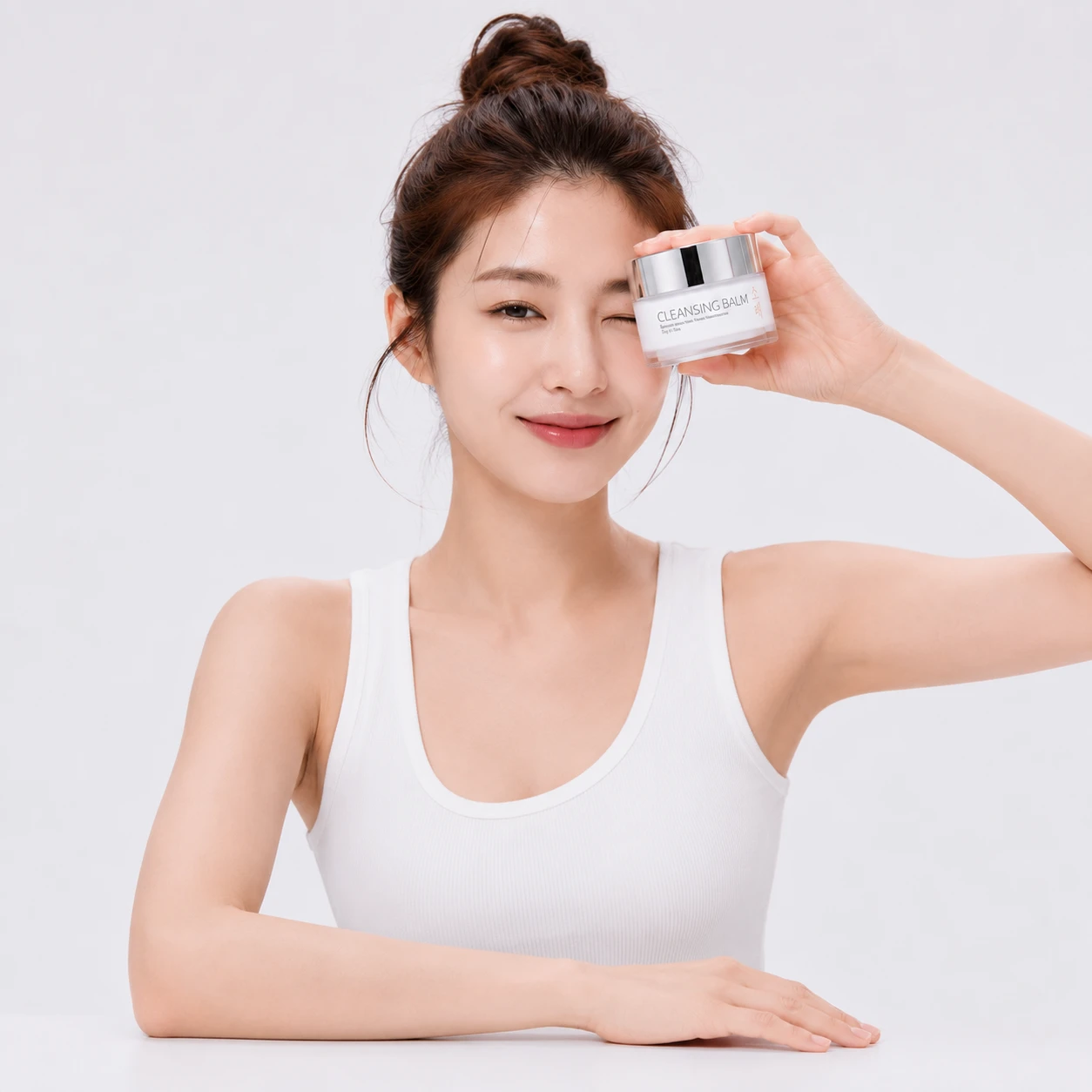 Model holding SOBAE Cleansing Balm beside her face